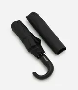 Paraguas plegable de color negro, con estructura metálica y mango curvo de plástico negro.