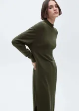 Vestido largo de punto fino color verde oliva, con diseño recto y holgado. Presenta cuello perkins, manga larga con terminaciones en canalé y aberturas laterales en el bajo.