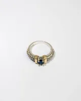 Anillo de plata 925 con dublé de oro, con una circonia azul central y zirconias blancas en el resto del anillo.