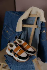 Championes color beige con detalles en marrón, con ajuste de velcro y suela track blanca y marrón.