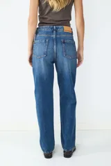 Jeans de tiro alto y corte recto, con diseño clásico de cinco bolsillos, cierre de cremallera y botón metálico.