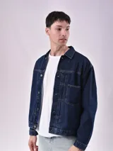 Campera de jean celeste con cuello clásico, cierre frontal con botones metálicos, bolsillos con solapa en el pecho y bolsillos laterales.