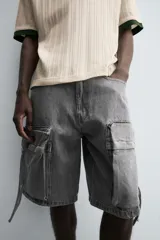 Bermuda de corte relajado en denim de algodón color beige, estilo cargo, con cinco bolsillos y bolsillos plastrón con solapa en las perneras.