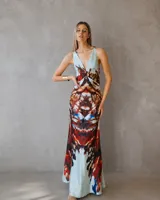 Vestido largo de corte al cuerpo con escote profundo en V y espalda descubierta. Confeccionado en tela fluida con estampado artístico en tonos celeste, terracota y azul.