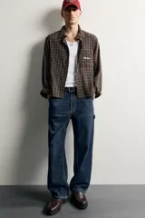 Pantalón jeans de corte relaxed fit, color celeste con efecto lavado, de estilo carpintero con bolsillos laterales y presillas de herramientas.