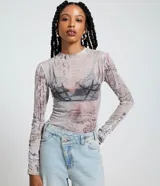 Blusa de manga larga y cuello alto en tejido de tul transparente, con estampado que simula textos manuscritos y un diseño gráfico de corsé en tonos grises y rosados.