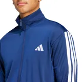 Conjunto deportivo Adidas Dayready Basic de tres tiras, color azul, compuesto por una campera de cierre frontal con cuello alto y un pantalón de jogging con bolsillos. Ambos elementos cuentan con las icónicas tres líneas blancas de la marca en los laterales y el logo estampado en el pecho y la pierna.