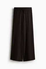 Pantalón de corte amplio confeccionado en tejido con textura tipo waffle, con cintura elástica y cordón ajustable.