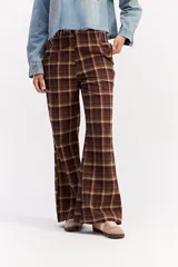 Pantalón de tiro medio con corte recto y leve apertura en el bajo, confeccionado en tela con estampado de cuadros en tonos marrones.