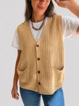 Chaleco de tejido de punto con textura, escote en V y cierre frontal con botones. Presenta dos bolsillos delanteros y terminaciones en tejido acanalado en el ruedo.