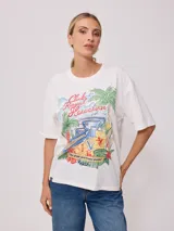 Remera amarilla de algodón con estampado de playa hawaiana con palmeras, flores y tabla de surf.