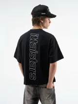 Remera negra oversize de manga corta, con estampa tipográfica vertical en la espalda y logo pequeño en el frente.