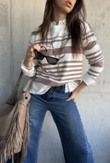 Sweater de punto fluido con diseño de rayas horizontales en color beige y blanco, de manga larga y silueta relajada.