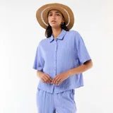 Camisa azul de manga corta con diseño de rayas verticales blancas, cuello camisero y cierre frontal con botones.