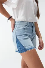 Short de denim blanco de tiro medio, con costuras pespuntadas en contraste y terminación desmechada en el ruedo.