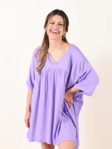 Vestido corto color lavanda, de corte suelto, con escote en V y mangas 3/4.