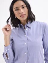 Camisa de corte clásico con estampado de rayas verticales finas en color azul y blanco, cuello camisero y cierre frontal con botones.