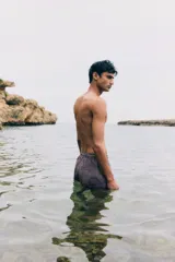 Short de baño de sirsaca con diseño a rayas verticales. Presenta cintura elástica con cordón de ajuste, bolsillos laterales y un bolsillo trasero abierto. Incluye suspensor interior de malla.