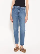 Jeans recto de tiro alto, tipo mom fit, con detalle desflecado en los laterales y diferencia de tonos entre el denim del delantero y de la espalda.