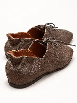 Zapato plano marrón de cuero vacuno con textura granulada, diseño acordonado de perfil bajo y suela fina.