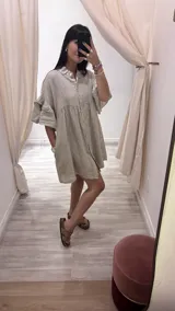 Vestido camisero blanco de lino italiano, con cuello camisero, cierre frontal con botones, mangas cortas con doble volado y bolsillos laterales.