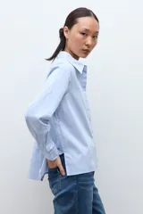 Camisa de manga larga color celeste, con cuello clásico y botones frontales.