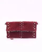 Bandolera de cuero gamuzado color marrón oscuro, con diseño rectangular y solapa frontal decorada con tachas metálicas plateadas. Incluye una cadena metálica plateada larga para usar al hombro o cruzada, y una cadena más corta para llevar como sobre.