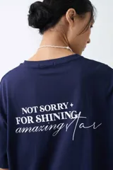 Remera de algodón gris melange con corte oversize, manga corta y estampa localizada en el frente con motivos deportivos en tonos verde y rosado.