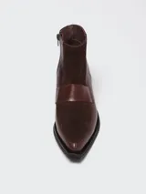 Botinetas de caña baja confeccionadas en una combinación de cuero napa y gamuza en tono bordó. Presentan un diseño de paneles con una banda central horizontal, puntera cuadrada y taco geométrico de color negro.