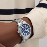 Reloj analógico Guess con caja y malla de acero inoxidable plateado. Presenta una esfera azul profundo de 44 mm con números arábigos, subesferas multifunción y movimiento de cuarzo.