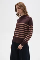 Polera de punto con diseño a rayas horizontales en contraste, cuello alto y mangas largas con puños ajustados.