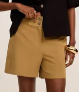 Bermuda roja de poliéster con cintura elástica, bolsillos laterales y cierre con cremallera y botones.