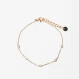Pulsera de cadena fina dorada con pequeños cristales engarzados a lo largo de la misma. Cuenta con cierre de mosquetón y cadena de alargue con un pequeño dije circular al final.
