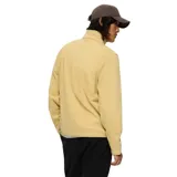 Buzo polar de micropolar ligero, color beige, con cuello subido y cierre frontal corto. Presenta logo de la marca bordado en el pecho y ribetes elásticos en puños y bajo.