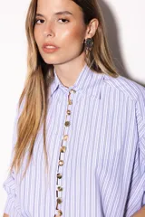 Camisa oversize a rayas celestes y blancas, con cuello camisero, manga larga y hilera de botones dorados metálicos.