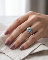 Anillo de plata y oro con circonia central redonda en tono aguamarina, rodeada de detalles texturizados.