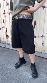 Bermuda negra de corte recto, con cintura elástica con cordón de ajuste y estampado de camuflaje.