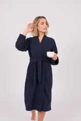Bata de polar con cuello solapa, mangas largas y lazo ajustable en la cintura. Presenta bolsillos frontales y un largo midi.