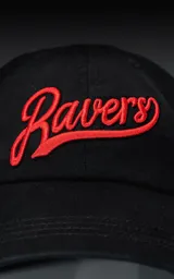 Gorra de gabardina negra con visera curva y bordado frontal en hilo rojo con la palabra "Ravers" en tipografía cursiva. Posee ajuste trasero de velcro.