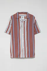 Camisa de manga corta con cuello solapa y cierre frontal con botones. Presenta un estampado de rayas verticales en tonos marrón, azul y blanco.