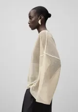 Jersey de punto malla color crema, con cuello en V y mangas largas japonesas.