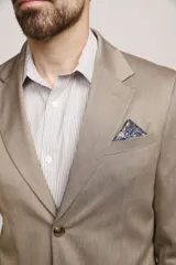 Ambo formal color tostado de corte clásico, compuesto por saco de dos botones con solapas de muesca y bolsillos con solapa, y pantalón recto a juego.
