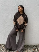 Sweater de punto con diseño de rombos en tonos gris oscuro y gris claro, de corte holgado, cuello redondo y manga larga.