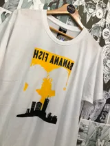 Remera blanca de manga corta con estampado de siluetas de personajes del anime Banana Fish sobre un fondo amarillo y un skyline negro.