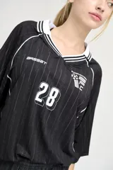 Camiseta de fútbol negra con rayas verticales finas blancas, cuello redondo con ribete blanco y número 28 estampado en el frente.