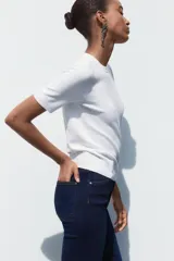 Jersey de punto fino con cuello redondo y manga corta, con terminaciones en rib en cuello, mangas y ruedo.