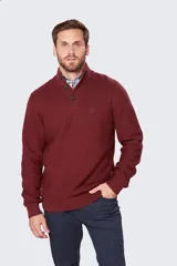 Buzo gris de tejido grueso con cuello alto y medio cierre con botones.