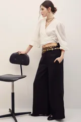 Pantalón negro de corte ancho y relajado, con tiro alto y bolsillos laterales.