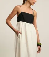 Vestido evasé midi de viscolino, con escote recto y breteles finos. Diseño bicolor con busto negro y falda blanca.