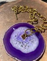 Collar de cadena de eslabones plateados con un dije central de piedra ágata natural en tono fucsia intenso con centro geoda.